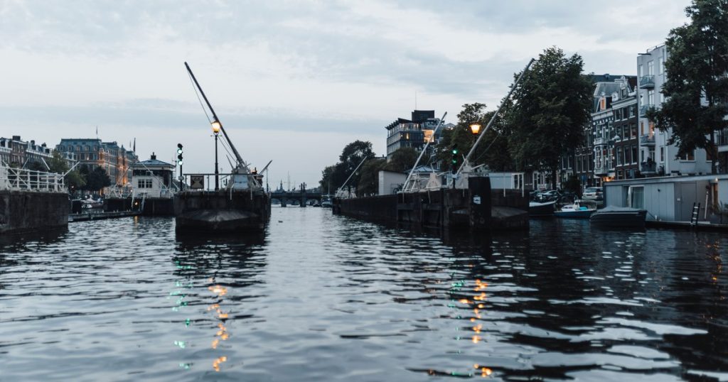Avondbeeld van een Amsterdamse gracht met karakteristieke panden langs het water