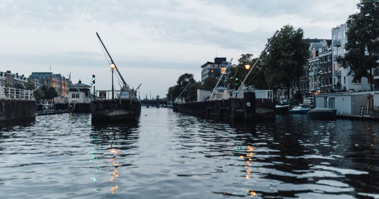 Avondbeeld van een Amsterdamse gracht met karakteristieke panden langs het water