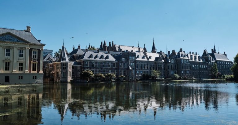 Historische panden weerspiegeld in een rustige stadsgracht