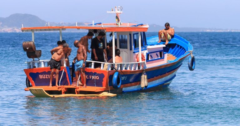 Een kleurrijke vissersboot met opvarenden op helder water tijdens een zonnige dag