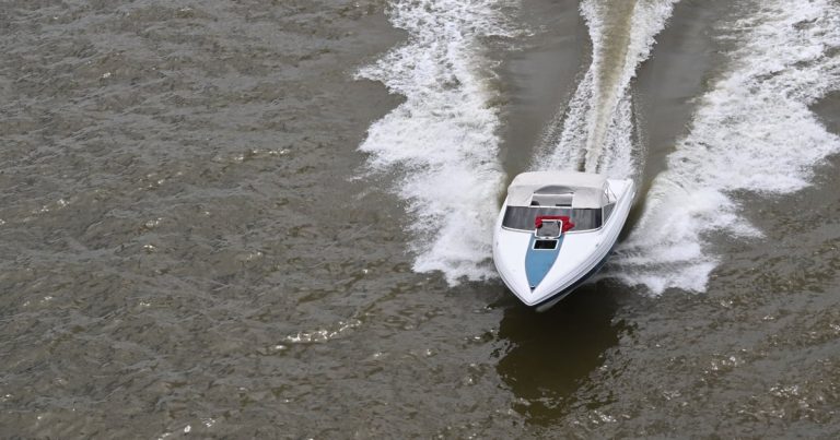 Een speedboot vaart met hoge snelheid over een rivier en trekt een spoor door het water