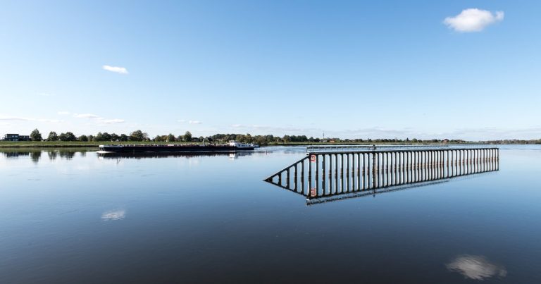 Rustig riviergezicht met spiegelend, kalm water