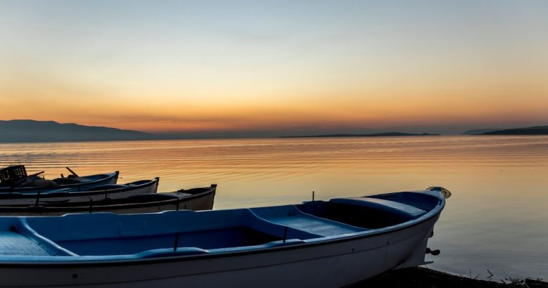Serene zonsondergang met boten aan een kalme kust