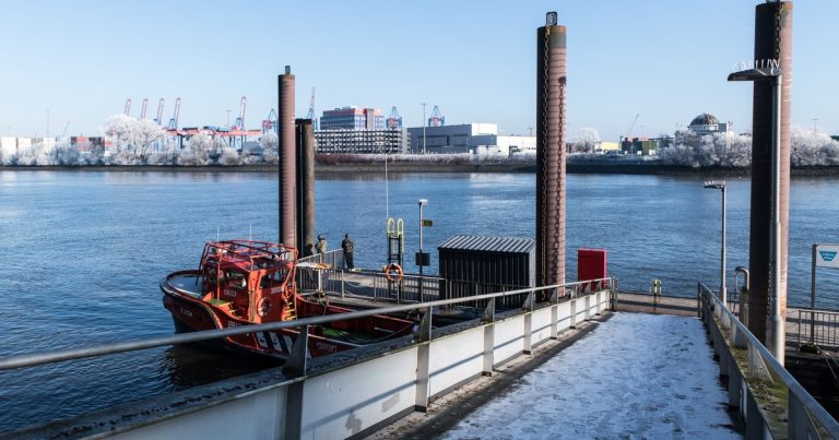 Serene winterse aanblik van de haven van Hamburg met een berijpte steiger en een afgemeerde boot.