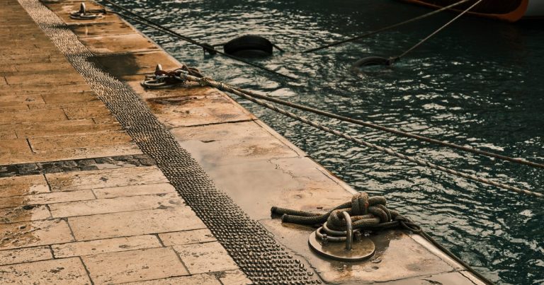 Afgemeerde boten en trossen aan een steiger in een jachthaven