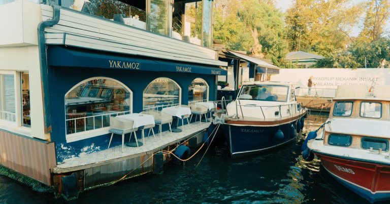 Een restaurant aan het water met boten afgemeerd voor de deur