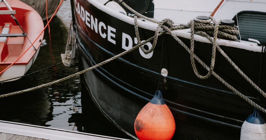 Close-up van landvasten en gekleurde stootwillen bij afgemeerde boten
