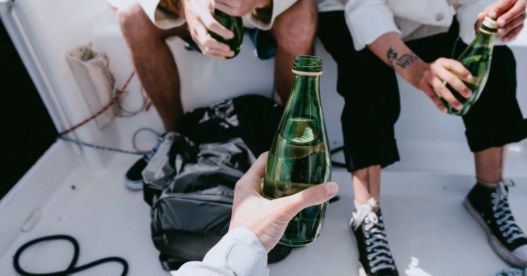 Vrienden met alcoholvrije drankjes aan boord van een jacht op het water