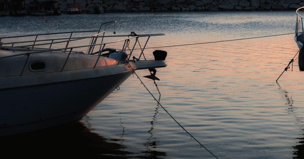 Voor anker liggende boten weerspiegeld in het water bij zonsondergang