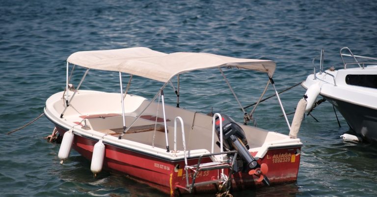 Een kleine vissersboot met zonnetent, afgemeerd aan rustig water