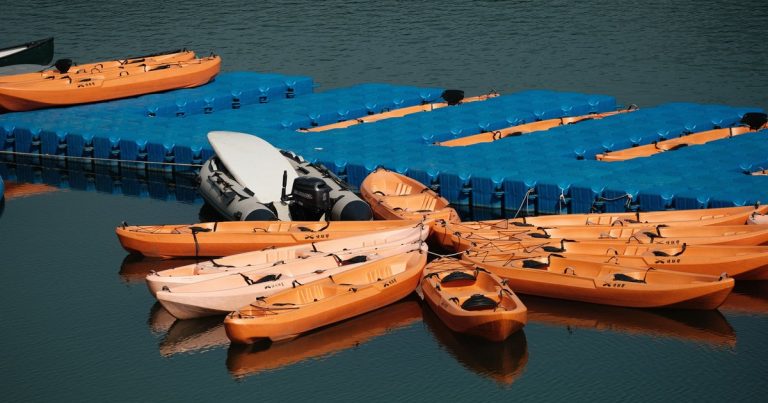 Oranje kajaks aan een blauwe steiger op kalm water