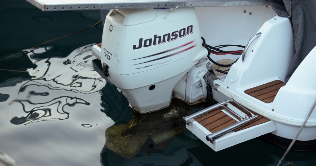 Close-up van een buitenboordmotor achter op een boot in rustig water