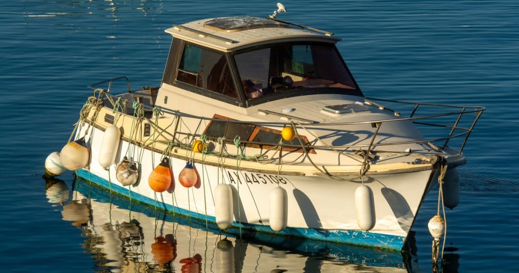 Een kleine boot met gekleurde stootwillen weerspiegelt in rustig water