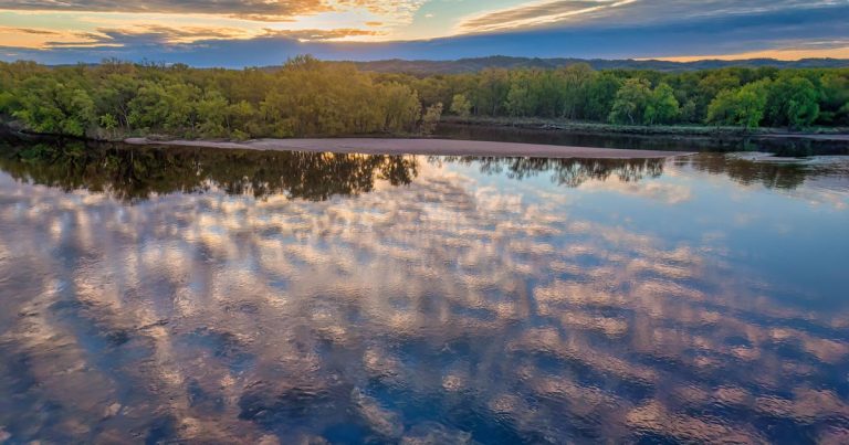 Zonsondergang boven een brede rivier