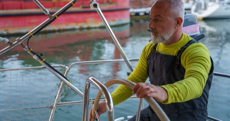 Een ervaren schipper aan het stuurwiel, geconcentreerd op het water voor zich