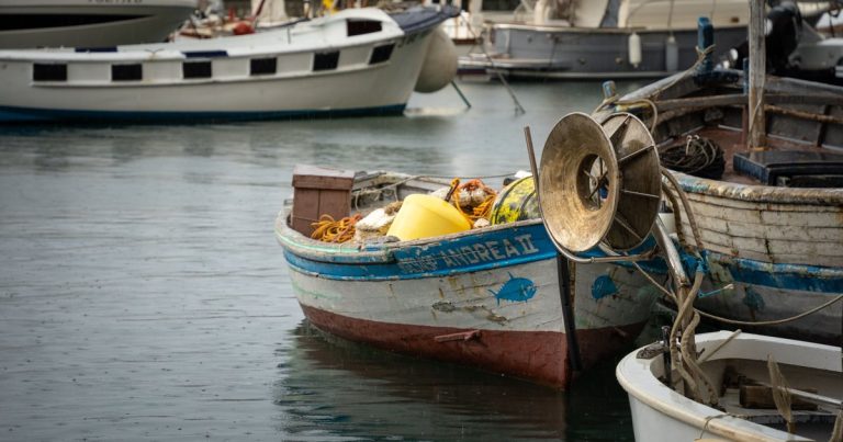 Rustieke vissersboten afgemeerd in de rustige haven van Camogli, Ligurië, Italië