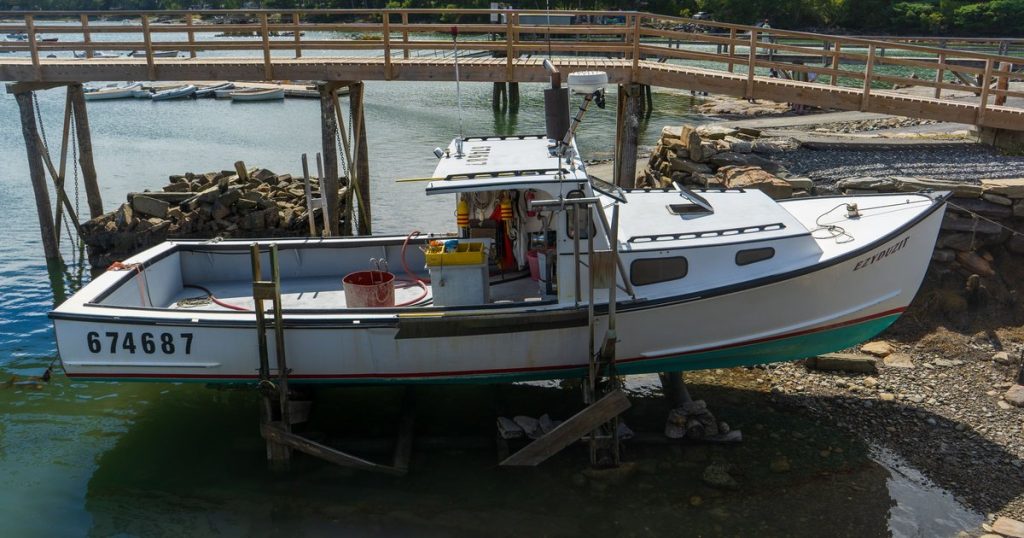 Een vissersboot op een droogdok langs een rustige jachthaven met houten steigers.