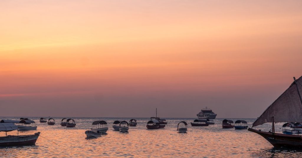 Rustige boten op het water bij zonsondergang in Tanzania, met vredige kleuren en weerspiegelingen