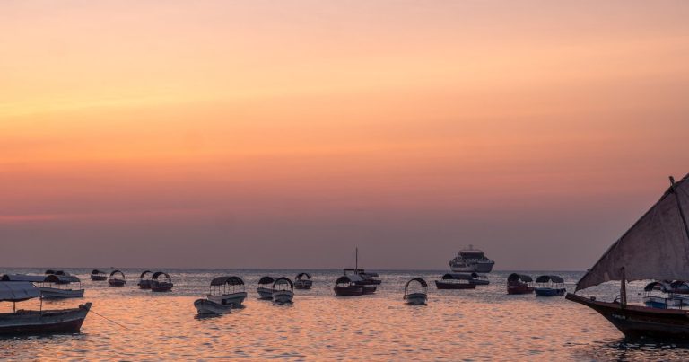 Rustige boten op het water bij zonsondergang in Tanzania, met vredige kleuren en weerspiegelingen