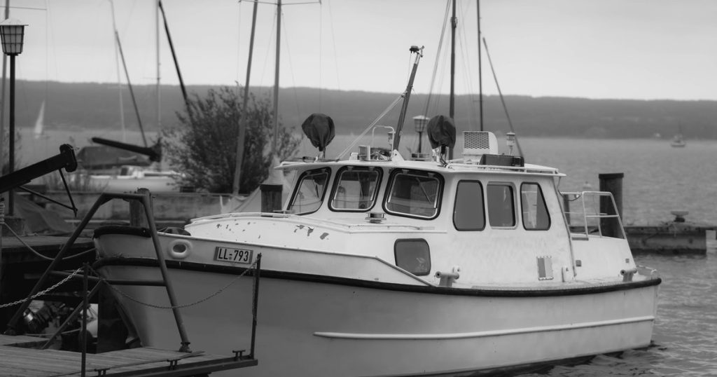 Zwart-witfoto van een jacht aangemeerd aan de Ammersee in Beieren, Duitsland, met rustig uitzicht over het meer