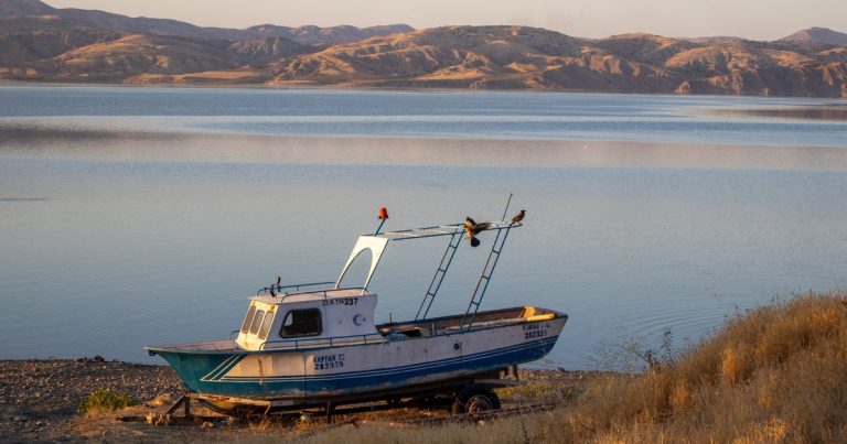 Vissersboot op de oever van het Keban-stuwmeer in Elazığ, Turkije, bij zonsondergang